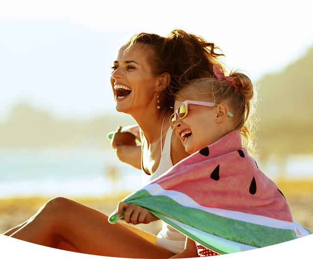 Madre e hija riendo y pasando tiempo en la playa