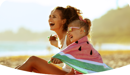 Madre e hija riendo y pasando tiempo en la playa